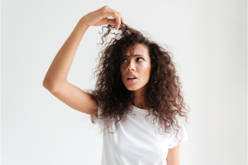 une femme qui regarde ses cheveux